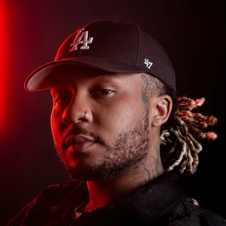 Portrait of Dre in a black LA cap, lit in red