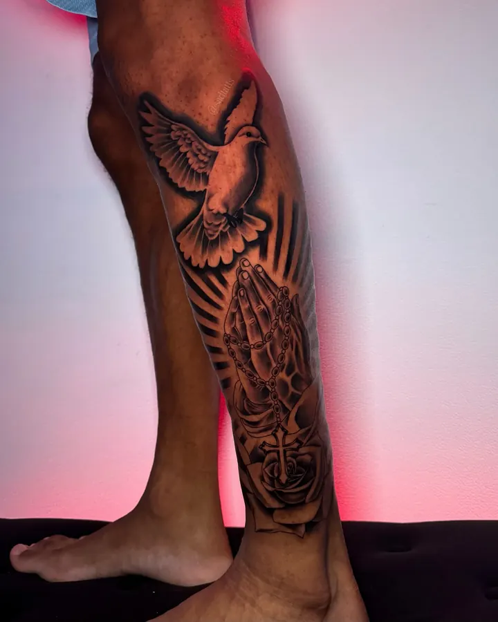Black and grey tattoo by Dre: dove and praying hands, leg