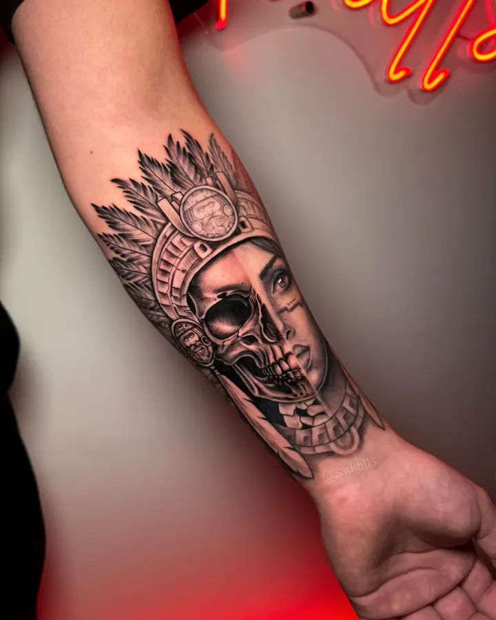 Black and grey tattoo by Dre: warrior woman and skull, forearm