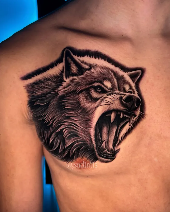 Black and grey tattoo by Dre: snarling wolf, chest