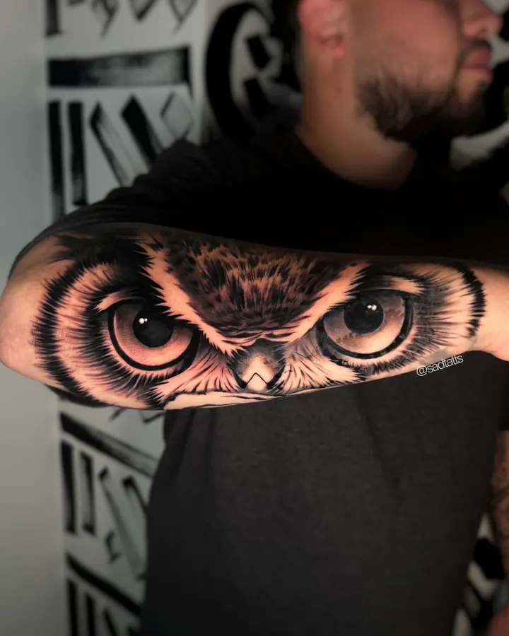Black and grey tattoo by Dre: owl eyes, forearm