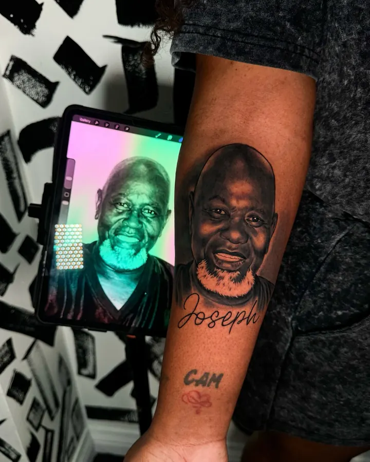 Black and grey tattoo by Dre: Portrait beside its photo reference, forearm